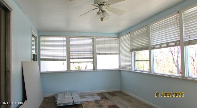 unfurnished sunroom featuring ceiling fan