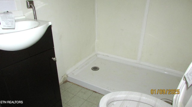 bathroom featuring vanity, tile patterned flooring, toilet, and a shower