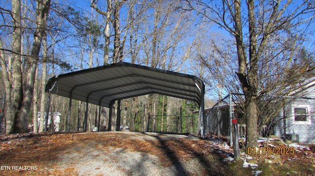 snow covered parking area with a carport