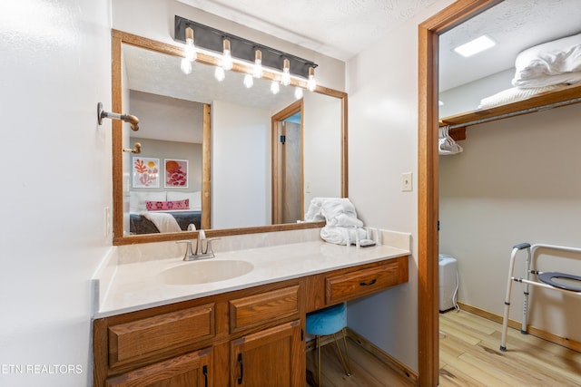 bathroom featuring vanity, wood-type flooring, and a textured ceiling