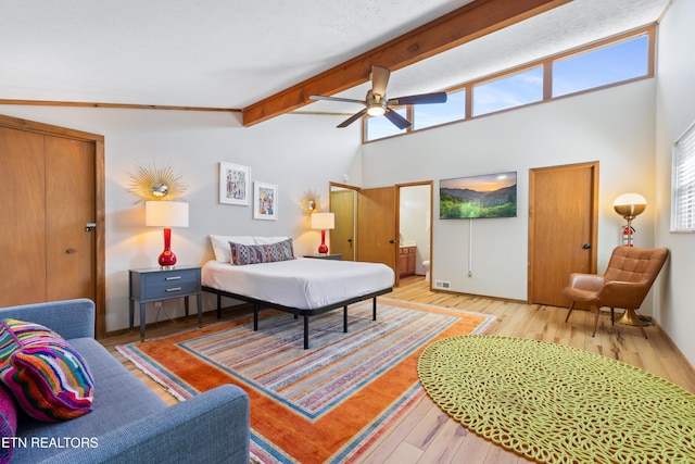 bedroom with ceiling fan, hardwood / wood-style floors, and lofted ceiling with beams