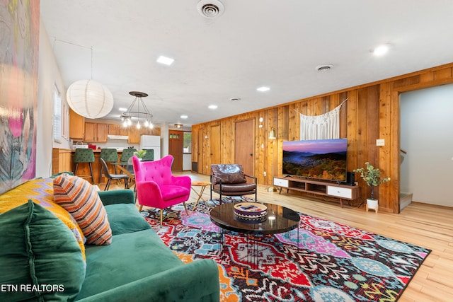 living room featuring light hardwood / wood-style floors and a notable chandelier