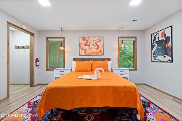 bedroom with light wood-type flooring and multiple windows