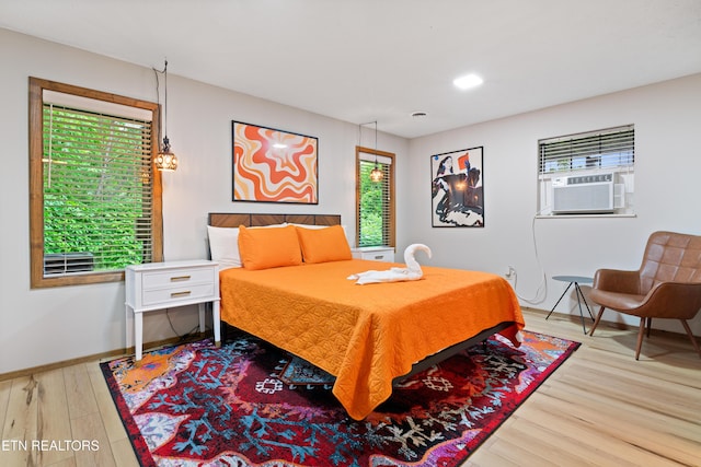 bedroom with cooling unit and light wood-type flooring