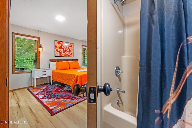 bathroom with wood-type flooring and shower / bath combo