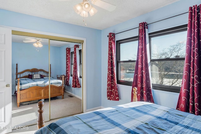 carpeted bedroom featuring a textured ceiling, a closet, and ceiling fan