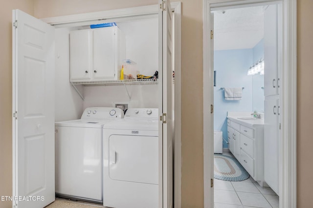 laundry room with sink, cabinets, a textured ceiling, light tile patterned flooring, and washer and dryer