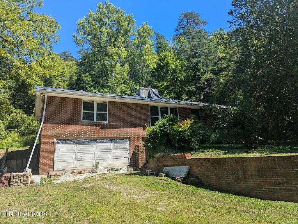 view of front of home with a front yard and a garage