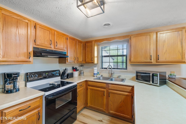 kitchen with black electric range, light wood-type flooring, a textured ceiling, and sink