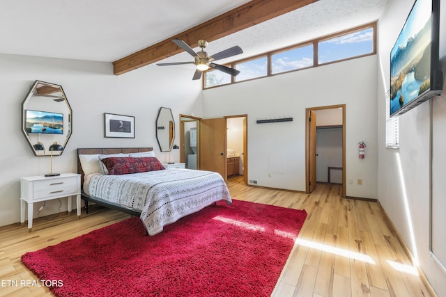 bedroom featuring ensuite bathroom, ceiling fan, beam ceiling, high vaulted ceiling, and light hardwood / wood-style flooring