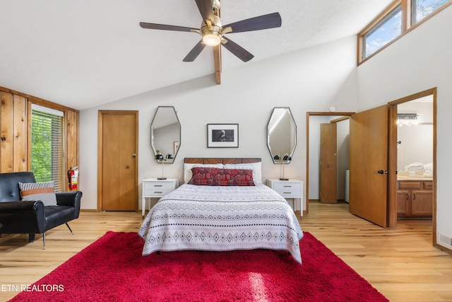 bedroom with ceiling fan, ensuite bathroom, vaulted ceiling, and light hardwood / wood-style floors