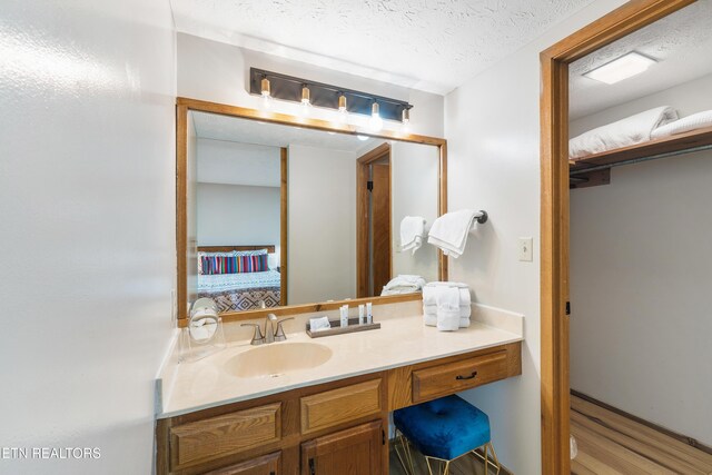 bathroom featuring vanity, hardwood / wood-style floors, and a textured ceiling