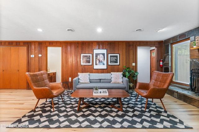 living room featuring wooden walls and light hardwood / wood-style floors