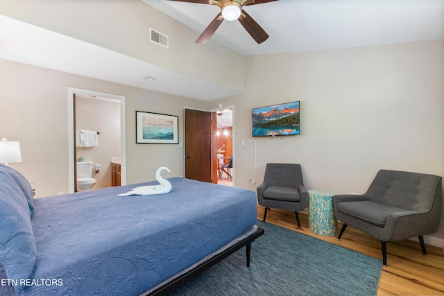 bedroom with ceiling fan, hardwood / wood-style floors, ensuite bathroom, and lofted ceiling