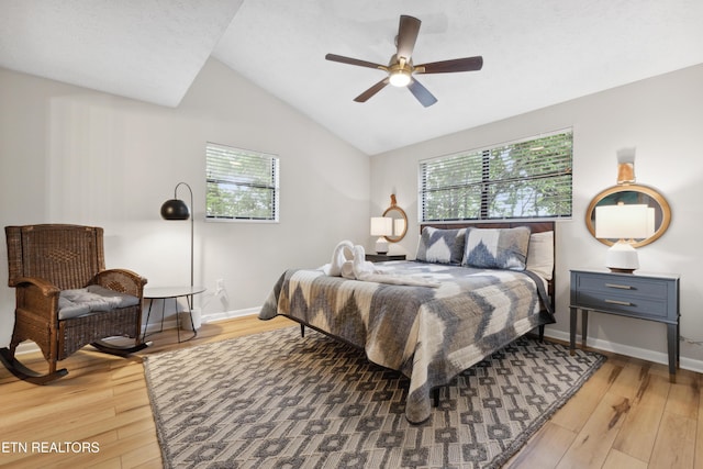 bedroom with ceiling fan, lofted ceiling, and hardwood / wood-style flooring