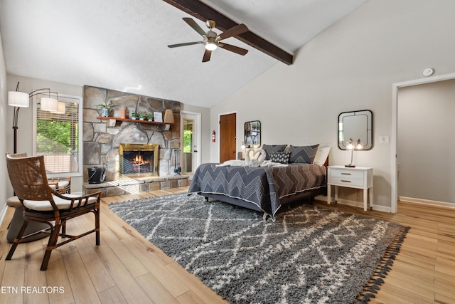 bedroom featuring hardwood / wood-style floors, ceiling fan, a fireplace, and multiple windows