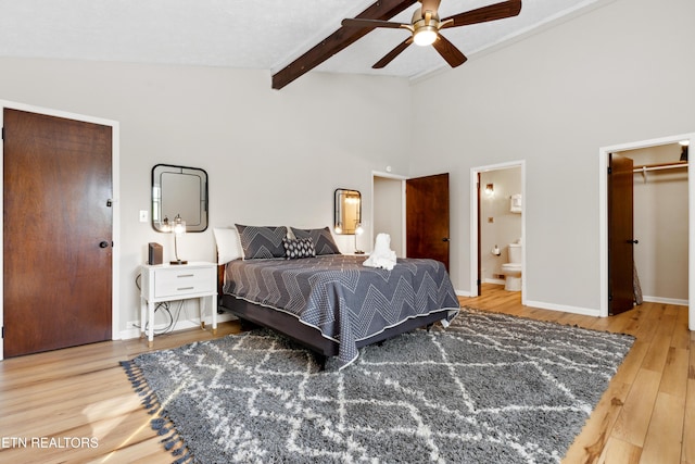 bedroom featuring hardwood / wood-style floors, ensuite bathroom, a walk in closet, ceiling fan, and a closet