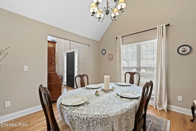 dining space featuring lofted ceiling, an inviting chandelier, and light hardwood / wood-style floors