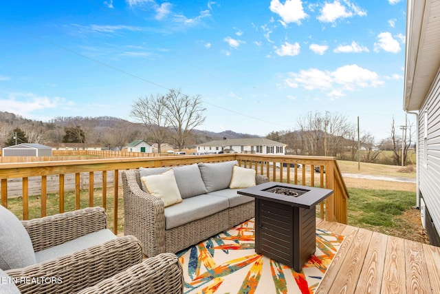 deck featuring a mountain view and an outdoor living space with a fire pit