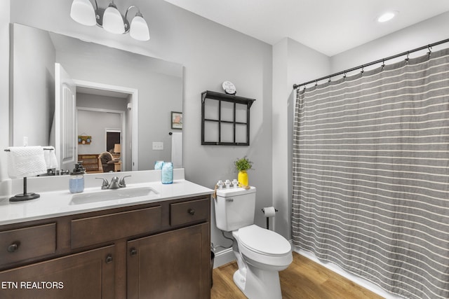 bathroom featuring vanity, toilet, and hardwood / wood-style floors