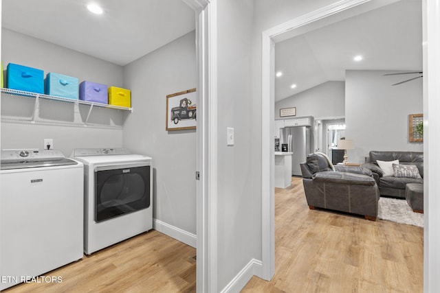 laundry area with washing machine and clothes dryer and light hardwood / wood-style flooring