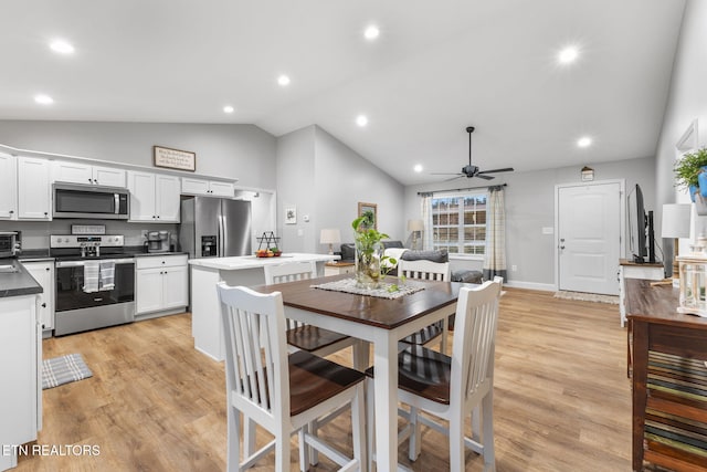 dining area featuring ceiling fan, high vaulted ceiling, and light hardwood / wood-style flooring