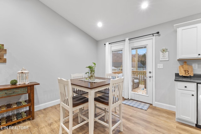 dining room featuring lofted ceiling and light hardwood / wood-style floors