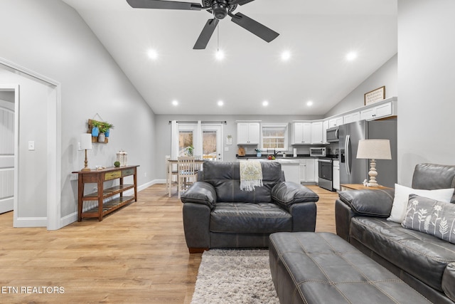 living room with lofted ceiling, light hardwood / wood-style flooring, and ceiling fan