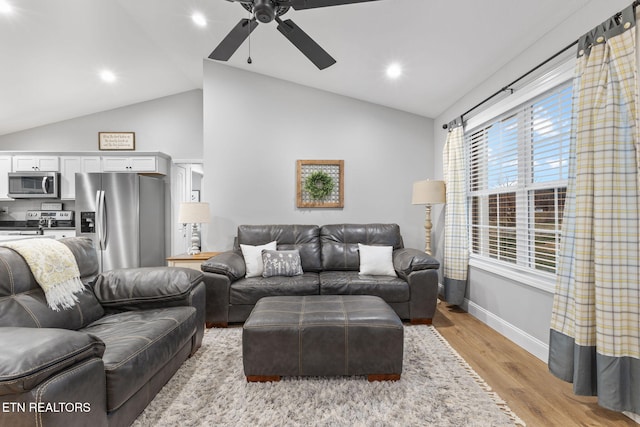 living room featuring vaulted ceiling, light hardwood / wood-style floors, and ceiling fan