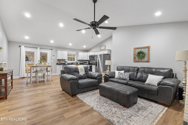 living room featuring lofted ceiling, ceiling fan, and light hardwood / wood-style flooring