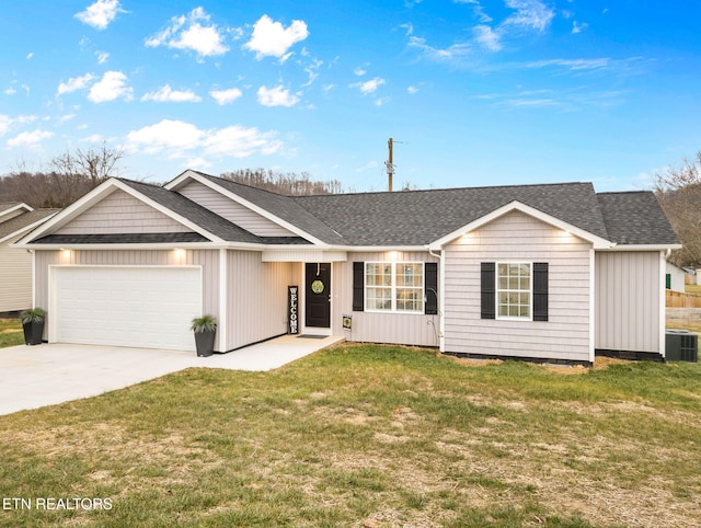 ranch-style home featuring cooling unit, a garage, and a front yard