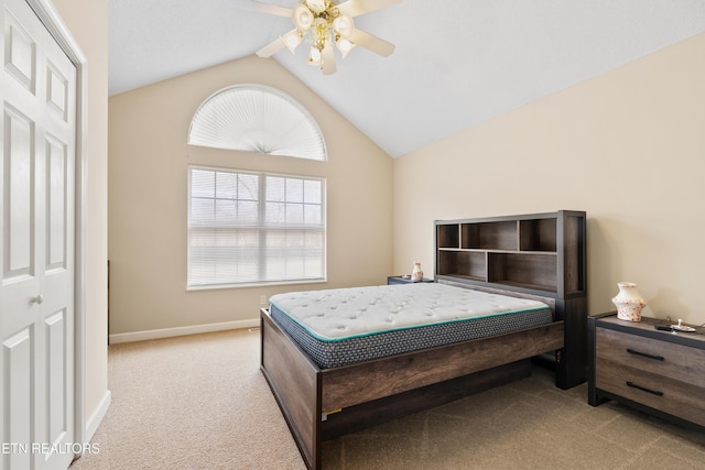 bedroom featuring a closet, vaulted ceiling, ceiling fan, and light colored carpet