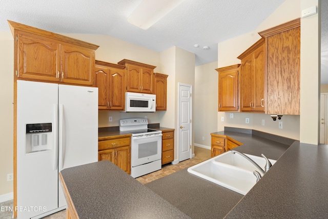 kitchen with lofted ceiling, white appliances, sink, and light tile patterned floors