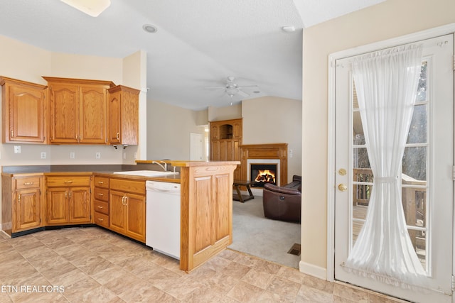 kitchen featuring white dishwasher, sink, ceiling fan, light colored carpet, and kitchen peninsula