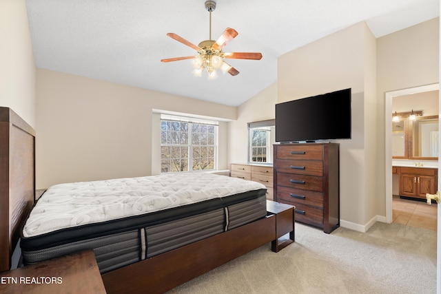 carpeted bedroom featuring ensuite bathroom, ceiling fan, and lofted ceiling