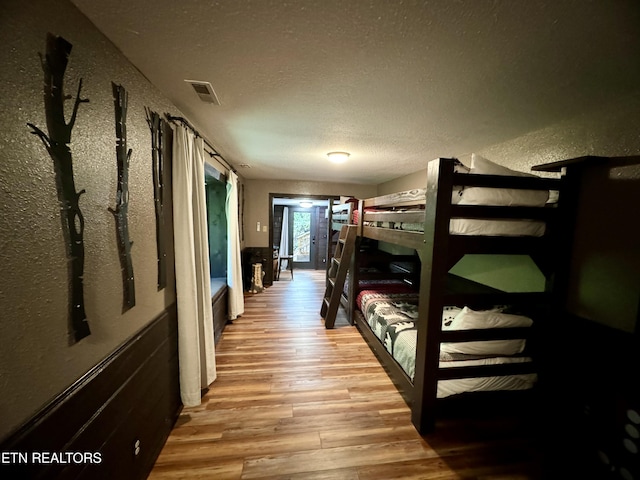 bedroom with light wood-type flooring and a textured ceiling