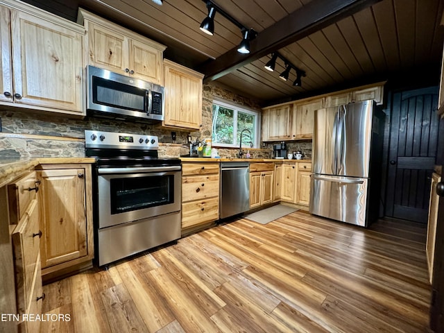 kitchen with rail lighting, light hardwood / wood-style flooring, light brown cabinetry, beam ceiling, and stainless steel appliances