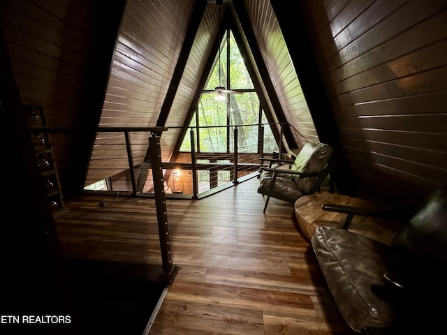 unfurnished room with wooden walls, wood ceiling, vaulted ceiling, and hardwood / wood-style flooring