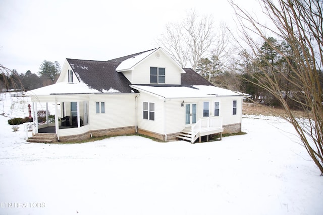 view of snow covered back of property