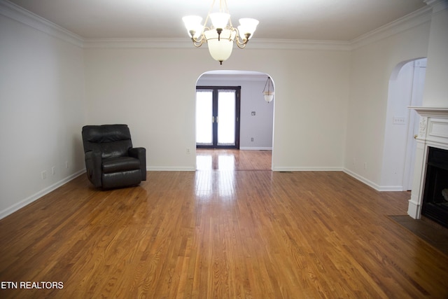 unfurnished room with crown molding, hardwood / wood-style floors, french doors, and a notable chandelier