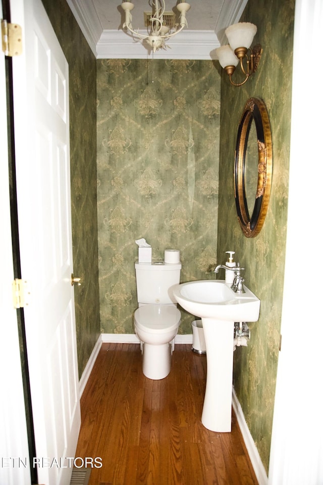 bathroom with hardwood / wood-style flooring, ornamental molding, and toilet