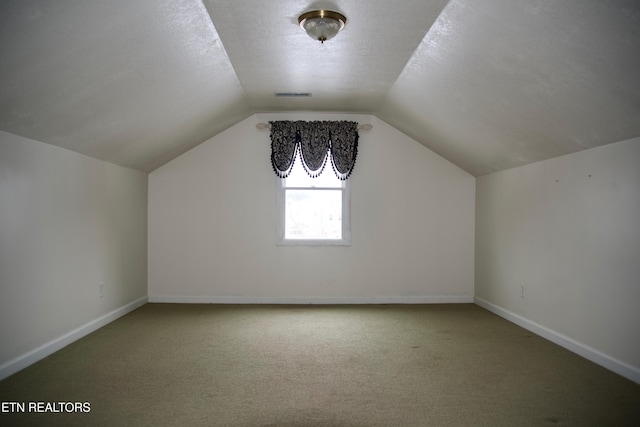 bonus room with lofted ceiling, carpet floors, and a textured ceiling