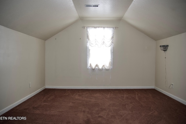 bonus room featuring lofted ceiling and dark carpet