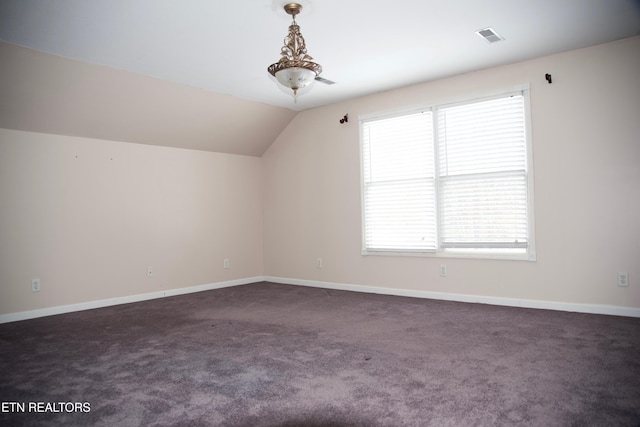 bonus room with lofted ceiling and dark carpet