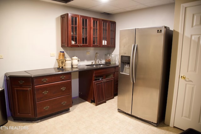 kitchen featuring sink, a drop ceiling, and stainless steel fridge with ice dispenser