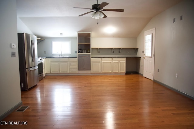 kitchen featuring sink, vaulted ceiling, stainless steel appliances, and light wood-type flooring