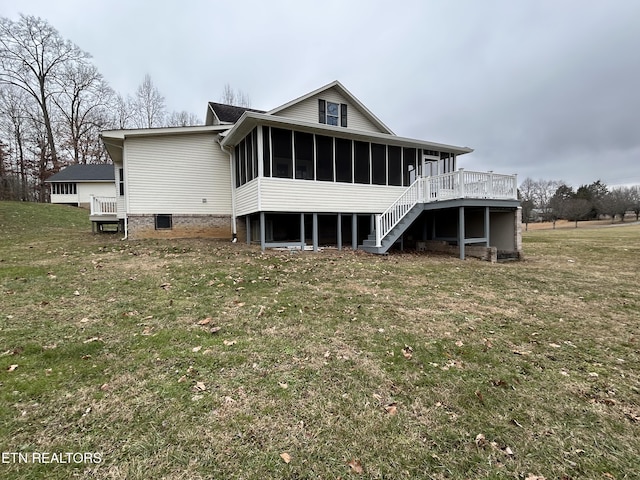 back of house with a wooden deck, a sunroom, and a yard