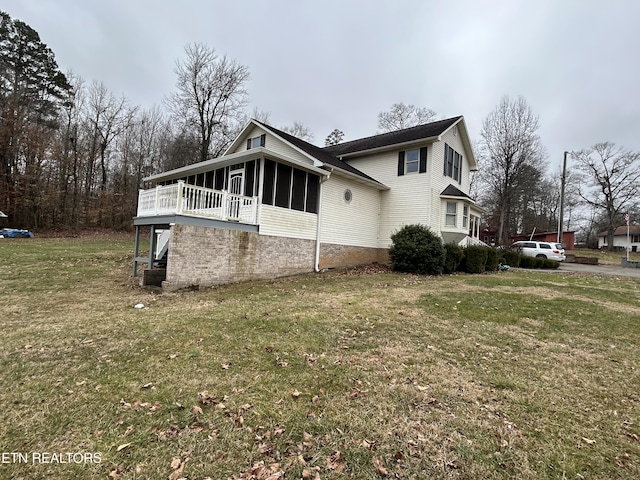 view of home's exterior featuring a yard and a sunroom