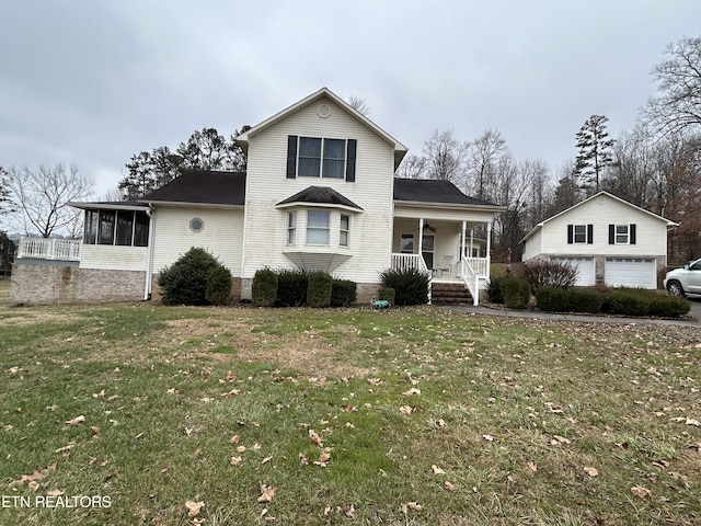 front facade featuring a garage, a sunroom, covered porch, and a front yard