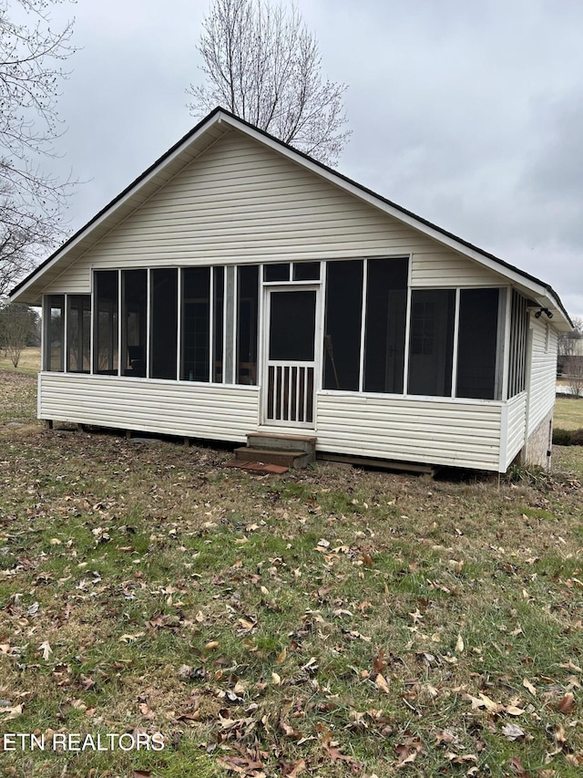 rear view of property with a sunroom